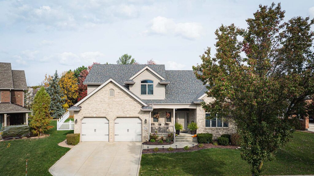 Aerial view of a house with a newly installed roof, showcasing expert roofing services for long-lasting protection.