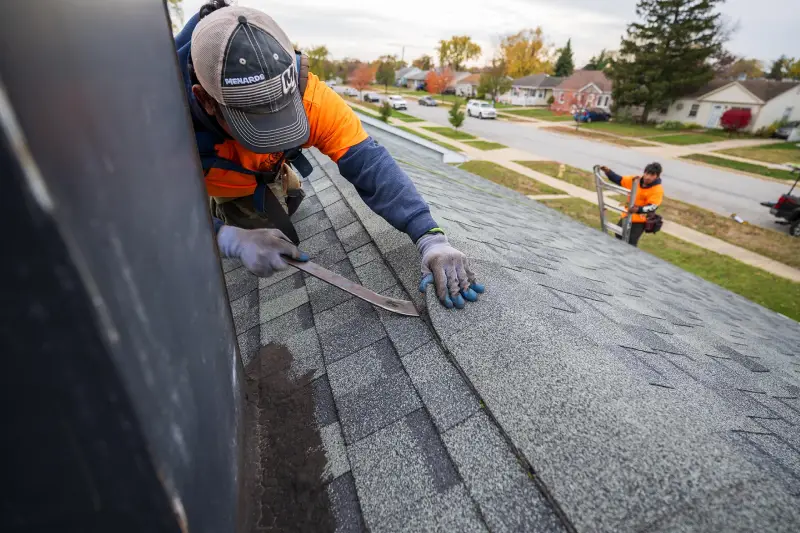 Professional roofers installing shingles on a home, providing reliable roofing services for durability and weather resistance.