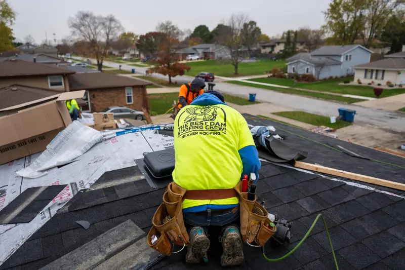 Skilled team working on roof installation, laying asphalt shingles for a strong and weather-resistant finish.
